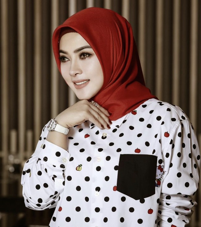 Semenjak menjalani liburan panjang selama empat bulan di Jepang bersama suaminya, Reini Barack, Syahrini muncul dengan penampilan barunya, yaitu memakai hijab. Syahrini memakai hijab segi empat merah yang hanya ia ikat rapi ke belakang dan dipadu dengan kemeja polkadot putih hitam.  Foto: Dok. Instagram @princessyahrini.