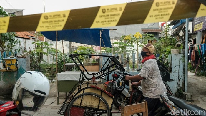 Gang Bahagia di Kelurahan Gerendeng, Karawaci, Tangerang, dilockdown imbas puluhan warga positif COVID-19. Garis Satpol PP dipasang di akses keluar masuk gang.