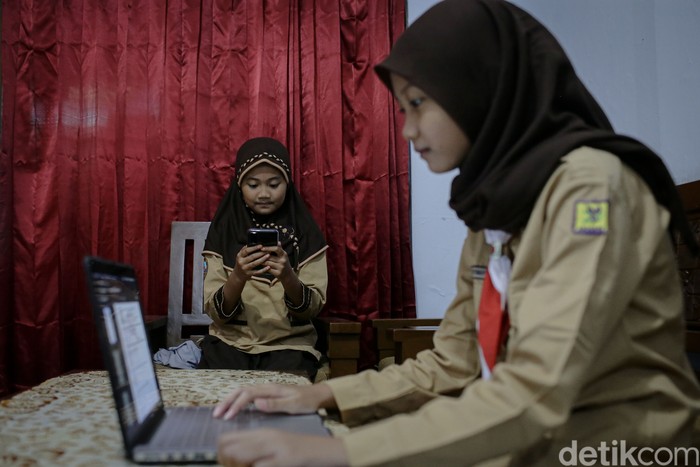 Rahma Aulia dan Kayla Putri siswi Sekolah Dasar Negeri Pademangan Barat 03 dan SDN Pademangan Barat 01 tengah mengikuti ujian sekolah secara daring dari rumah, Jakarta, Rabu (9/6/2021).