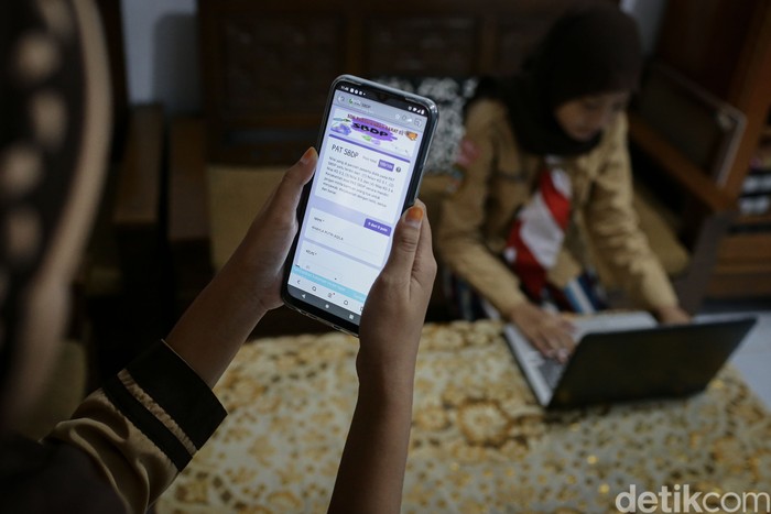 Rahma Aulia dan Kayla Putri siswi Sekolah Dasar Negeri Pademangan Barat 03 dan SDN Pademangan Barat 01 tengah mengikuti ujian sekolah secara daring dari rumah, Jakarta, Rabu (9/6/2021).