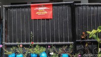 Warga yang reaktif menempeli pagar rumahnya dengan stiker isolasi mandiri.