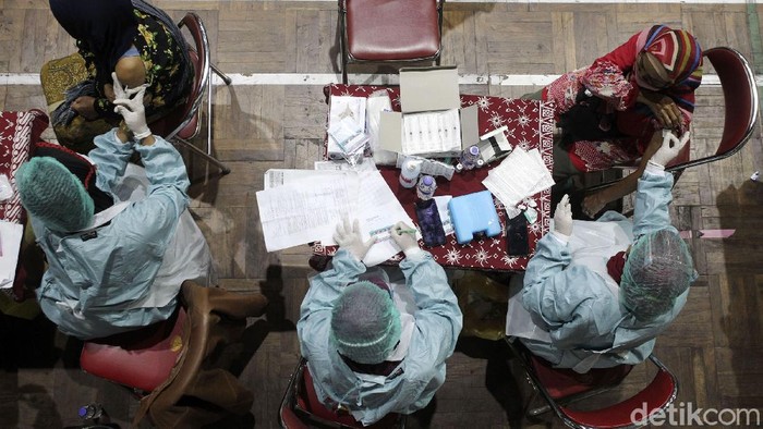 Pedagang pasar Sleman mengikuti vaksinasi di GOR Pangukan, Sleman, Yogyakarta, Rabu (9/6/2021). Dinas Kesehatan (Dinkes) Kabupaten Sleman menargetkan sebanyak 11.000 pedagang pasar tradisional divaksin hingga akhir Juni ini. Pelaksanaan vaksinasi Covid-19 AstraZeneca bagi pedagang pasar di Sleman dimulai 9 Juni 2021.