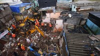 Selain banjir, hujan lebat juga menyebabkan sebuah bangunan tempat tinggal tiba-tiba ambruk di daerah kumuh Mumbai, India.   