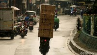 Seorang pemotor mengangkut kulkas di kawasan Ciputat, Tangerang Selatan, Kamis (10/6/2021).