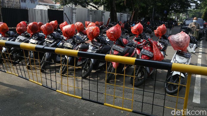 Berbagai cara dilakukan guna mencegah tertular virus Corona. Di Blok M, seorang tukang parkir membungkus ratusan helm konsumennya dengan kantong plastik.
