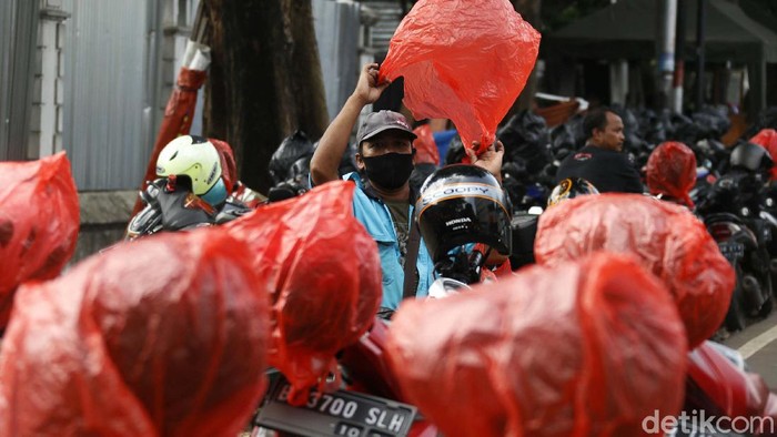 Berbagai cara dilakukan guna mencegah tertular virus Corona. Di Blok M, seorang tukang parkir membungkus ratusan helm konsumennya dengan kantong plastik.