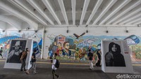 Warga melintas di depan pameran foto yang merupakan bagian dari Jakpreneur Fest di terowongan Jl Kendal, Jakarta, Kamis (10/6/2021).
