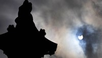 Selain Amerika Serikat dan Kanada, fenomena gerhana matahari cincin pun turut terlihat di langit Kota London, Inggris. (AP Photo/Frank Augstein)
