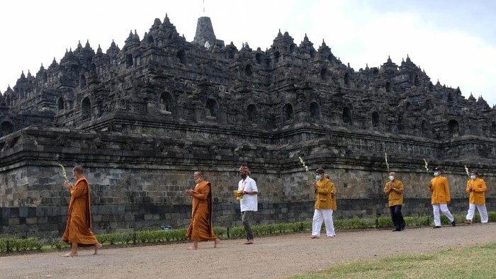 Sejumlah umat Budha melaksanakan Pradaksina (berjalan mengelilingi) candi Borobudur saat upacara Upostha Mandala Puja di kawasan Taman Wisata Candi (TWC) Borobudur, Magelang, Jawa Tengah, Kamis (10/6/2021). Ritual Uphosata Mandala Puja rutin dilaksanakan dua kali dalam sebulan yaitu pada tanggal satu dan tanggal lima belas penanggalan Jawa untuk membersihkan pikiran dari hal-hal kotor. ANTARA FOTO/Anis Efizudin/hp.