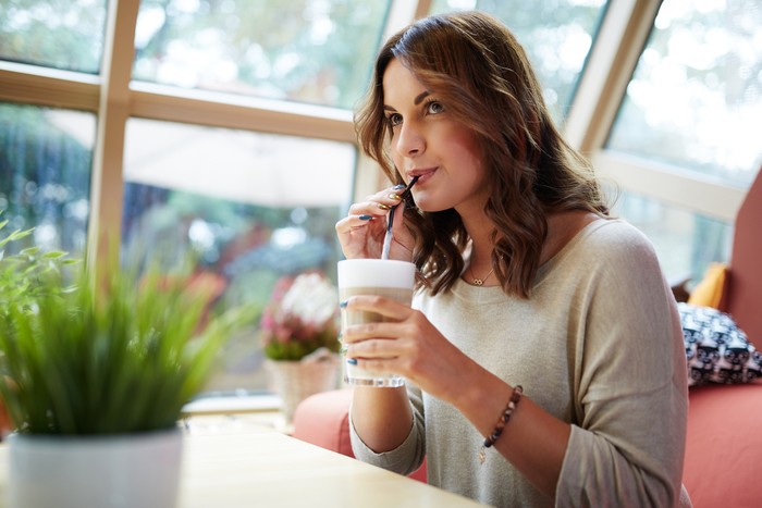 Portrait of young beautiful woman relaxing at cafe drinking coffee.