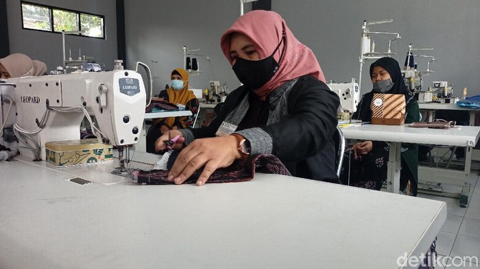 Seorang ibu tengah menjahit