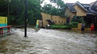 Warga memantau arus air yang masuk dan menyebabkan banjir di Perumahan Nerada Estate Ciputat, Tangerang Selatan, Banten.