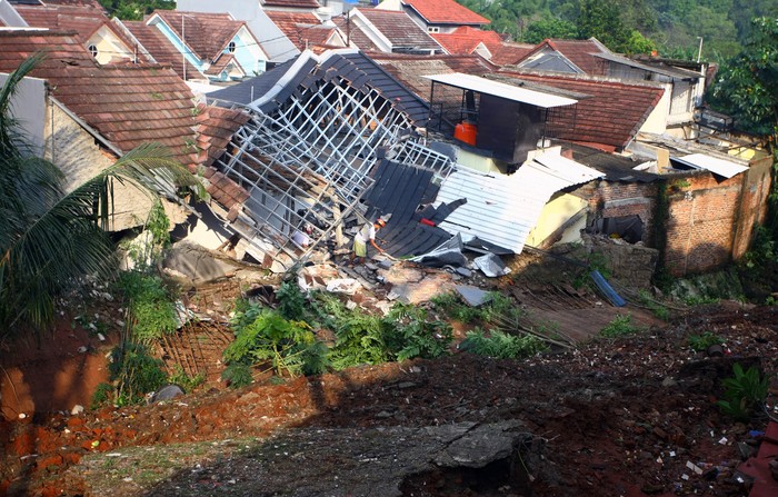Warga memantau arus aiir yang masuk dan menyebabkan banjir di perumahannya akibat jebolnya tanggul karena tertimpa tanah longsor, di Perumahan Nerada Estate Ciputat, Tangerang Selatan, Banten, Sabtu (12/6/2021). Longsor yang menimpa sejumlah rumah disebabkan hujan deras yang terus menerus di kawasan tersebut dan tidak ada korban jiwa dalam peristiwa itu. ANTARA FOTO/Muhammad Iqbal/hp.