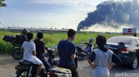 Sesekali pengendara motor maupun mobil menyempatkan diri untuk berhenti dan mengambil gambar kepulan asap hitam tersebut.