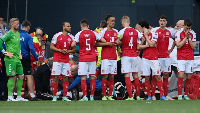 1323215466 COPENHAGEN, DENMARK - JUNE 12: Denmark players surround Christian Eriksen (Hidden) of Denmark as he receives medical treatment during the UEFA Euro 2020 Championship Group B match between Denmark and Finland on June 12, 2021 in Copenhagen, Denmark. (Photo by Stuart Franklin/Getty Images)