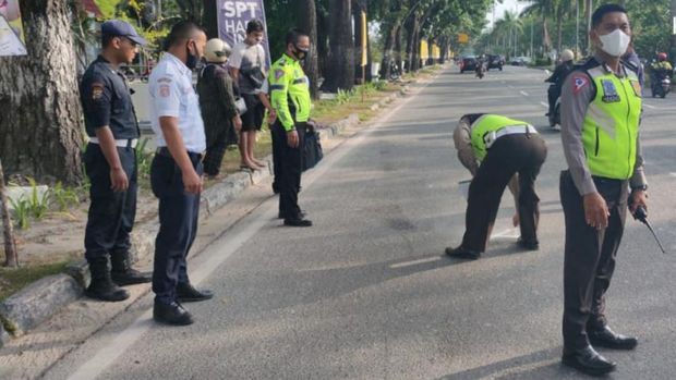 Polisi saat melakukan olah TKP di lokasi kecelakaan mobil seruduk motor, sepeda dan pejalan kaki.