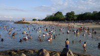 Seperti pantauan detikFinance, Minggu (13/6/2021), wisatawan lokal membludak di Pantai Sanur, bahkan lokasi parkir kendaraan sampai penuh sesak. Para wisatawan menghabiskan waktunya di pantai dengan berbagai macam kegiatan, mulai dari sekadar duduk di pasir, bermain dengan anak-anak, berenang dan berbagai macam kegiatan lainnya. (Sui Suadnyana/detikcom)
