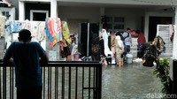 Sebagian warga lainnya mengeringkan pakaian yang basah di pagar rumah.
