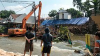 Warga menyaksikan perbaikan turap dari perumahan Griya Satwika Telkom yang berada di atas. Perumahan Nerada yang berada di bawah turut terdampak.