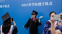 Seorang wisudawan berfoto tanpa menggunakan masker di Central China Normal University, Minggu (14/6/2021).