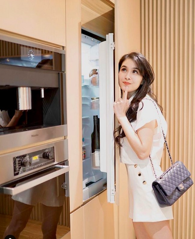 Kulkas istri Harvey Moeis ini memang tak biasa. Berkonsep built-in, kulkas Sandra Dewi seolah menyatu dengan lemari dapur. Untuk menjawab rasa penasaran, ia mengunggah sebuah foto khusus yang memperlihatkannya sedang membuka pintu kulkas. Iniloh penampakan kulkas yg jadi sahabatku selama pandemi teman teman (buat yg kemaren nanya mana kulkasnya hahahaha). (Foto: Instagram/@sandradewi88)