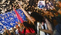Balai Kota Tel Aviv diselimuti cahaya yang memproyeksikan bendera nasional Israel.