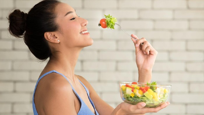 Ilustrasi Diet Asian woman in joyful postures with hand holding salad bowl