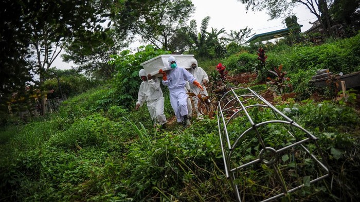 Sejumlah tenaga pikul beristirahat setelah memakamkan jenazah dengan protokol COVID-19 di TPU Cikadut, Bandung, Jawa Barat, Selasa (15/6/2021). Petugas pikul jenazah mengatakan, pemakaman jenazah dengan protokol COVID-19 di TPU Cikadut mengalami peningkatan sebanyak 20 hingga 30 jenazah per hari dibandingkan dengan bulan lalu yang hanya lima hingga delapan jenazah per hari. ANTARA FOTO/Raisan Al Farisi/foc.