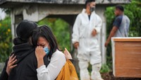 Keluarga menangis saat menyaksikan pemakaman jenazah dengan protokol COVID-19 di TPU Cikadut, Bandung, Jawa Barat, Selasa (15/6/2021).  