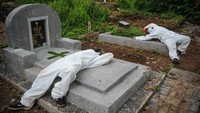 Sejumlah tenaga pikul beristirahat setelah memakamkan jenazah dengan protokol COVID-19 di TPU Cikadut, Bandung, Jawa Barat, Selasa (15/6/2021).   