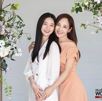 Mereka pun berpose di antara dekor bunga. Eugene memeluk Kim Hyun Soo dari belakang, dan memegang tangannya. Ia mengenakan dress off shoulder berwarna peach, sementara putrinya mengenakan blazer dan rok putih. Foto: dok. Instagram studiowonkyu