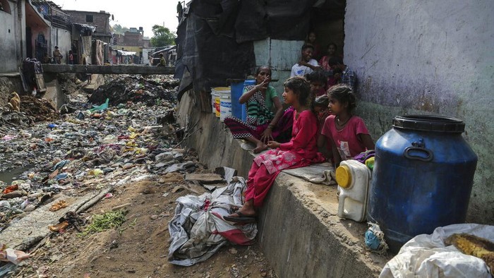 Kala Anak-anak Pemukiman Kumuh di India Ikut Kelas Online A teacher gestures as children wearing face masks as a precaution against the coronavirus attend online classes at a slum on the outskirts of Jammu, India, Monday, June 14, 2021. (AP Photo/Channi Anand)