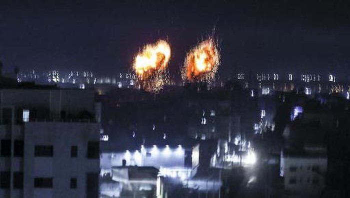 Khianati Gencatan Senjata, Israel Kembali Serang Gaza Explosions light-up the night sky above buildings in Gaza City as Israeli forces shell the Palestinian enclave, early on June 16, 2021. (Photo by Mahmud hams / AFP)