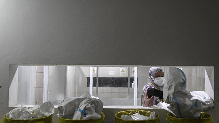 Seorang tenaga kesehatan membuang baju hazmat usai bertugas merawat pasien di Rumah Sakit Darurat COVID-19 (RSDC) Wisma Atlet Kemayoran, Jakarta, Selasa(15/6/2021). Menurut Koordinator RSDC Wisma Atlet Kemayoran Mayjen TNI Tugas Ratmono, pihaknya menambah jumlah kapasitas tempat tidur menjadi 7.394 dari 5.994 akibat tingginya penularan COVID-19 di wilayah DKI Jakarta dan sekitarnya. ANTARA FOTO/M Risyal Hidayat/nz