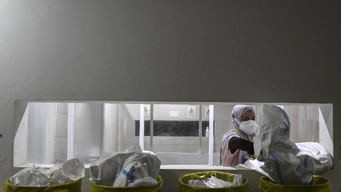 RSDC WISMA ATLET KEMAYORAN TAMBAH KAPASITAS TEMPAT TIDUR Seorang tenaga kesehatan membuang baju hazmat usai bertugas merawat pasien di Rumah Sakit Darurat COVID-19 (RSDC) Wisma Atlet Kemayoran, Jakarta, Selasa(15/6/2021). Menurut Koordinator RSDC Wisma Atlet Kemayoran Mayjen TNI Tugas Ratmono, pihaknya menambah jumlah kapasitas tempat tidur menjadi 7.394 dari 5.994 akibat tingginya penularan COVID-19 di wilayah DKI Jakarta dan sekitarnya. ANTARA FOTO/M Risyal Hidayat/nz
