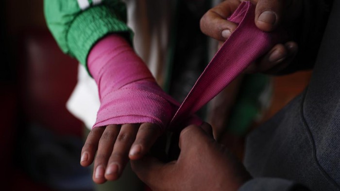 Tangan Batu Gadis Bolivia Ambisikan Tinju Profesional Gracce Kelly Flores, a 12-year-old boxer who goes by the nickname Hands of Stone, right, poses for a photo with her family after her daily boxing workout and breakfast in Palca, Bolivia, early Thursday, June 10, 2021, amid the COVID-19 pandemic. At age 8, Flores defeated a 10-year-old boy, and with three national boxing medals under her belt, she dreams of reaching the women's boxing world championship. (AP Photo/Juan Karita)