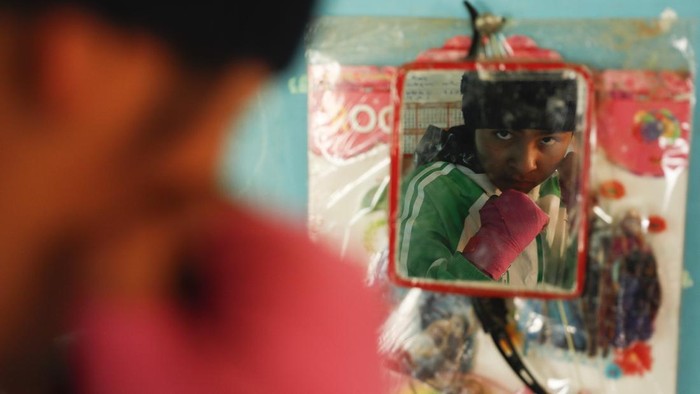 Gracce Kelly Flores, a 12-year-old boxer who goes by the nickname Hands of Stone, right, poses for a photo with her family after her daily boxing workout and breakfast in Palca, Bolivia, early Thursday, June 10, 2021, amid the COVID-19 pandemic. At age 8, Flores defeated a 10-year-old boy, and with three national boxing medals under her belt, she dreams of reaching the women's boxing world championship. (AP Photo/Juan Karita)