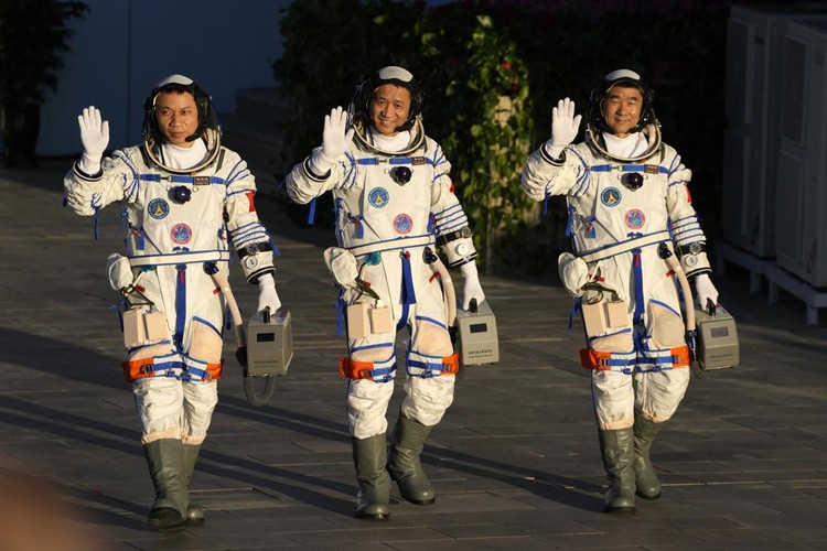 Chinese astronauts, from left, Tang Hongbo, Nie Haisheng, and Liu Boming wave as they prepare to board for liftoff at the Jiuquan Satellite Launch Center in Jiuquan in northwestern China, Thursday, June 17, 2021. China plans on Thursday to launch three astronauts onboard the Shenzhou-12 spaceship who will be the first crew members to live on Chinas new orbiting space station Tianhe, or Heavenly Harmony. (AP Photo/Ng Han Guan)