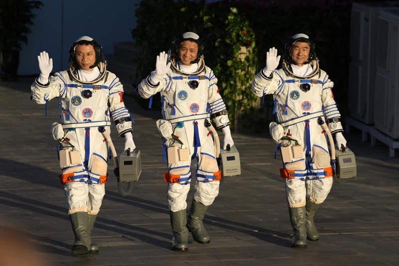 Chinese astronauts, from left, Tang Hongbo, Nie Haisheng, and Liu Boming wave as they prepare to board for liftoff at the Jiuquan Satellite Launch Center in Jiuquan in northwestern China, Thursday, June 17, 2021. China plans on Thursday to launch three astronauts onboard the Shenzhou-12 spaceship who will be the first crew members to live on China's new orbiting space station Tianhe, or Heavenly Harmony. (AP Photo/Ng Han Guan)