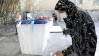 Salah satunya dengan memasang penyekat plastik di dekat kotak suara. AP Photo/Ebrahim Noroozi.  