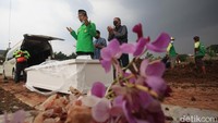 Para petugas dan pihak keluarga yang melakukan proses pemakaman jenazah korban COVID-19 di TPU Jombang, Tangerang Selatan, Jumat (18/6/2021). Foto: Ari Saputra