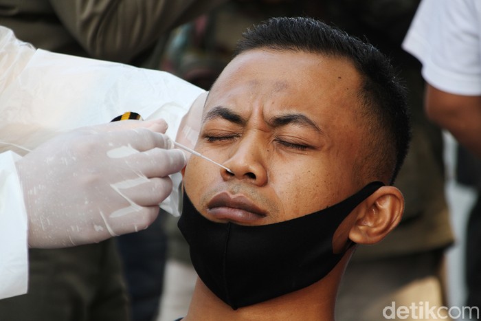 Petugas gabungan gelar razia masker di kawasan Solo. Warga yang kedapatan melanggar prokes pun ditindak dengan diwajibkan melakukan swab test di tempat.