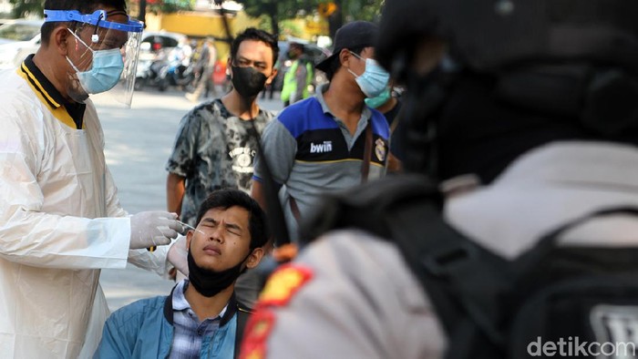 Petugas gabungan gelar razia masker di kawasan Solo. Warga yang kedapatan melanggar prokes pun ditindak dengan diwajibkan melakukan swab test di tempat.