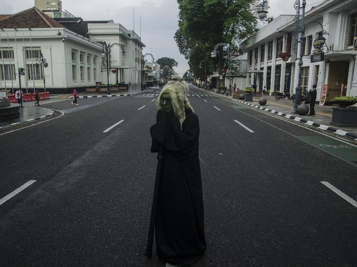 Cosplayer hantu berdiri di tengah ruas jalan protokol kawasan Asia Afrika yang ditutup di Bandung, Jawa Barat, Jumat (18/6/2021). Warga menikmati suasana ruas jalan protokol di Kota Bandung yang lengang setelah ditutup untuk menekan peningkatan kasus aktif COVID-19 dan status siaga satu kawasan Bandung Raya. ANTARA FOTO/Novrian Arbi/rwa.