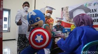 Tak sampai di situ Captain America pun menerima suntik vaksin dosis pertama. Dia bersama tokoh boneka L.O.L menerima vaksin di Balai Desa Loram Kulon. 