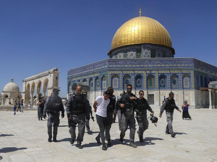 Masked Palestinians wearing the Palestinian flag during clashes with Israeli security forces stand n front of the Dome of the Rock Mosque at the Al Aqsa Mosque compound in Jerusalems Old City, Friday, June 18, 2021. Hundreds demonstrated after Friday prayers in response to a rally held by Jewish ultranationalists on Tuesday in which dozens had chanted 