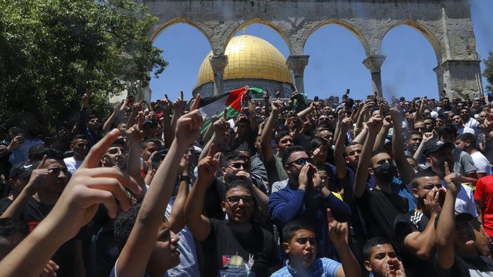 Israel Palestinians Masked Palestinians wearing the Palestinian flag during clashes with Israeli security forces stand n front of the Dome of the Rock Mosque at the Al Aqsa Mosque compound in Jerusalem's Old City, Friday, June 18, 2021. Hundreds demonstrated after Friday prayers in response to a rally held by Jewish ultranationalists on Tuesday in which dozens had chanted