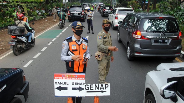 PEMBERLAKUAN ATURAN GANJIL GENAP DI KOTA BOGOR Petugas gabungan mengatur lalu lintas saat pemberlakuan aturan ganjil genap di Jalan Pajajaran, Kota Bogor, Jawa Barat, Sabtu (19/6/2021). Pemkot Bogor kembali memberlakukan aturan ganjil genap untuk kendaraan roda dua dan empat pada setiap akhir pekan untuk mengurangi mobilitas warga sekaligus mengendalikan lonjakan kasus positif COVID-19 di Kota Bogor yang mencapai 204 kasus pada Kamis (17/6/2021). ANTARA FOTO/Arif Firmansyah/rwa.