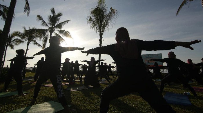 Warga melakukan gerakan yoga di Pantai Ketapang Indah, Banyuwangi, Jawa Timur, Sabtu (19/6/2021). Perkumpulan Praktisi Yoga Nasional Indonesia-Banyuwangi memperingati hari Yoga Internasional yang jatuh pada 21 Juni mendatang dengan tema 