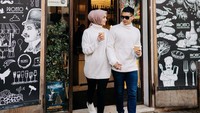 Bulan madu keliling Eropa, Rezky dan Citra kompak pakai outfit putih. Keduanya pose sambil membawa segelas kopi di tangan.